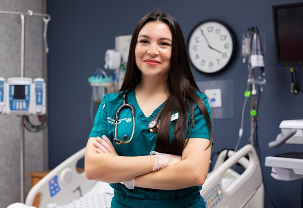 Lizbeth Mora stand facing the camera with arms crossed and smiling.