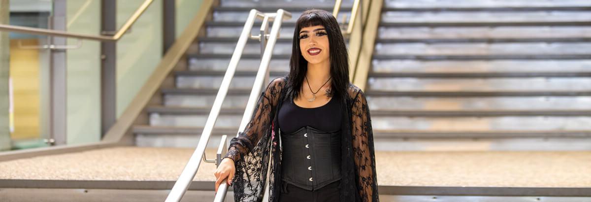 Maleah Manning stands smiling on a staircase at Pima's West Campus