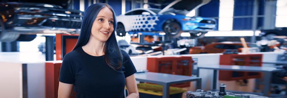 爱丽丝 stands facing the camera in Pima's Automotive Technology Center