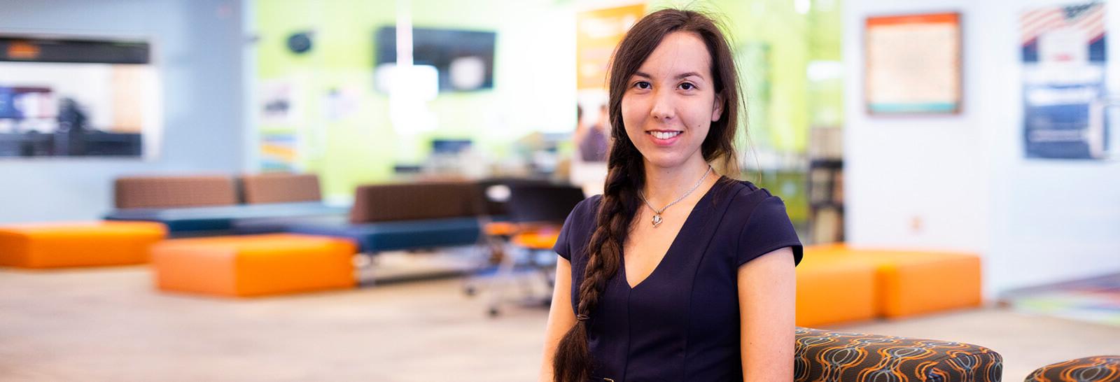 Kira Okuma Poses smiling in Pima's Northwest Campus Student Life Center