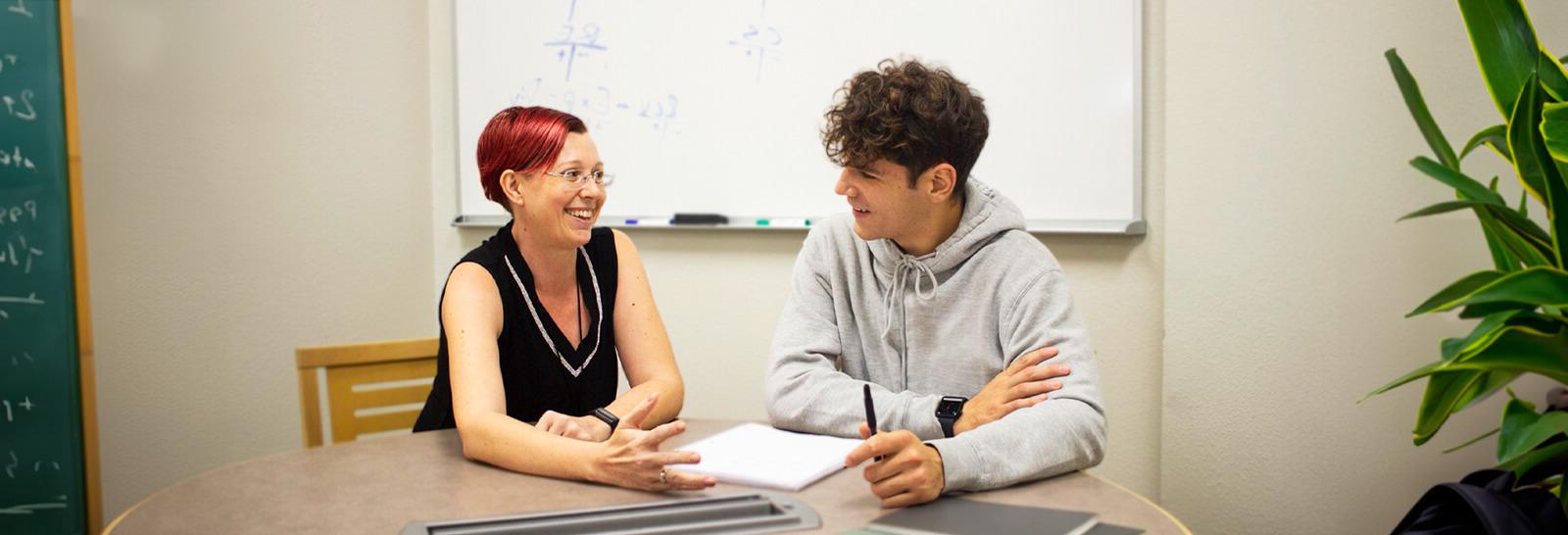 萨曼莎Overton sits at a table in a study room with a student studying